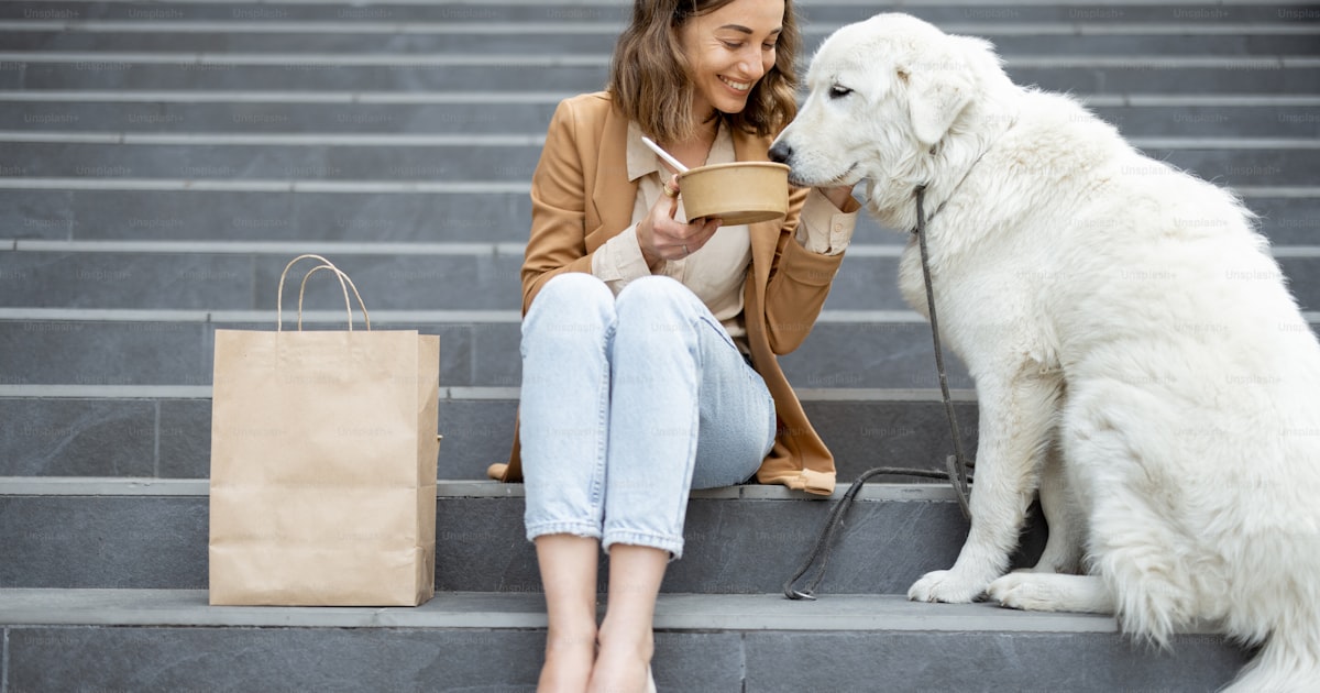 Large white dog enjoying mealtime outdoors with owner